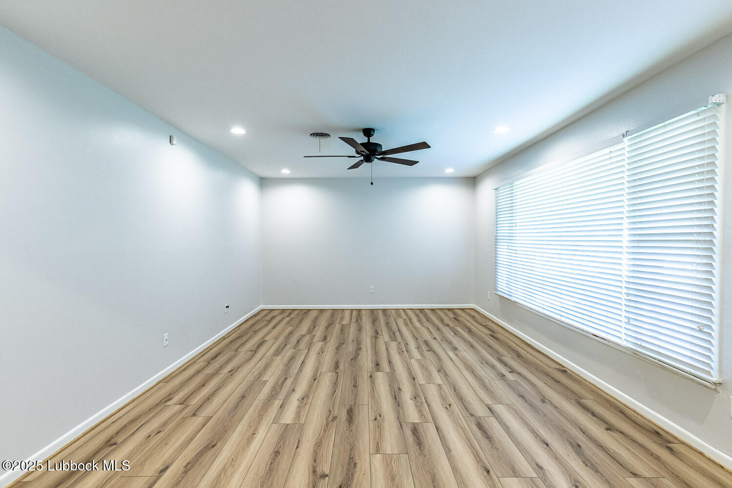 2601 33rd Street Lubbock, TX 79410 - Photo 5 of 30 an empty room with a ceiling fan and window