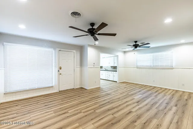a view of a kitchen with wooden floor and a ceiling fan