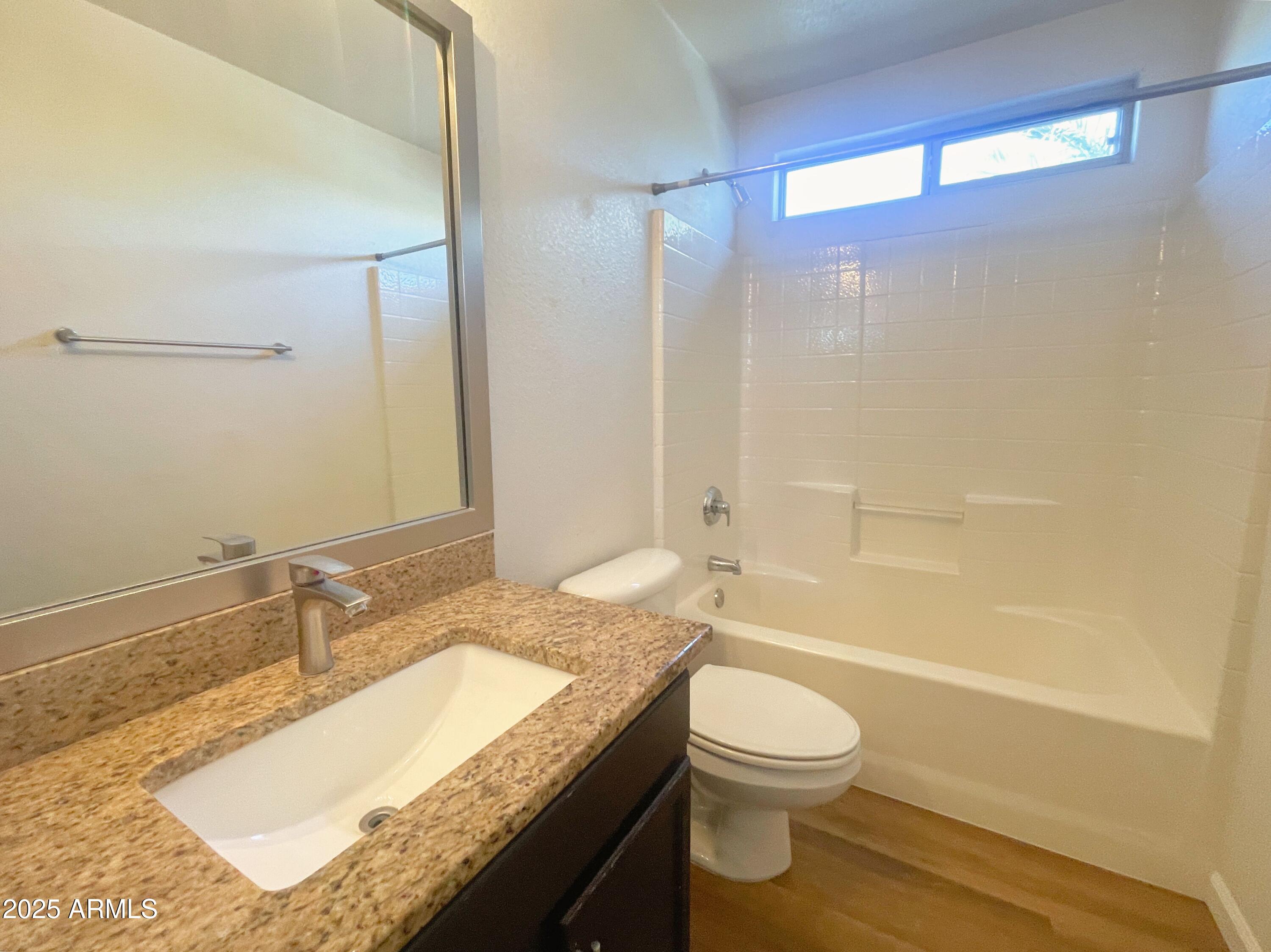 2211 South Harper Mesa, AZ 85209 - Photo 23 of 27 a bathroom with a granite countertop sink toilet a mirror and shower
