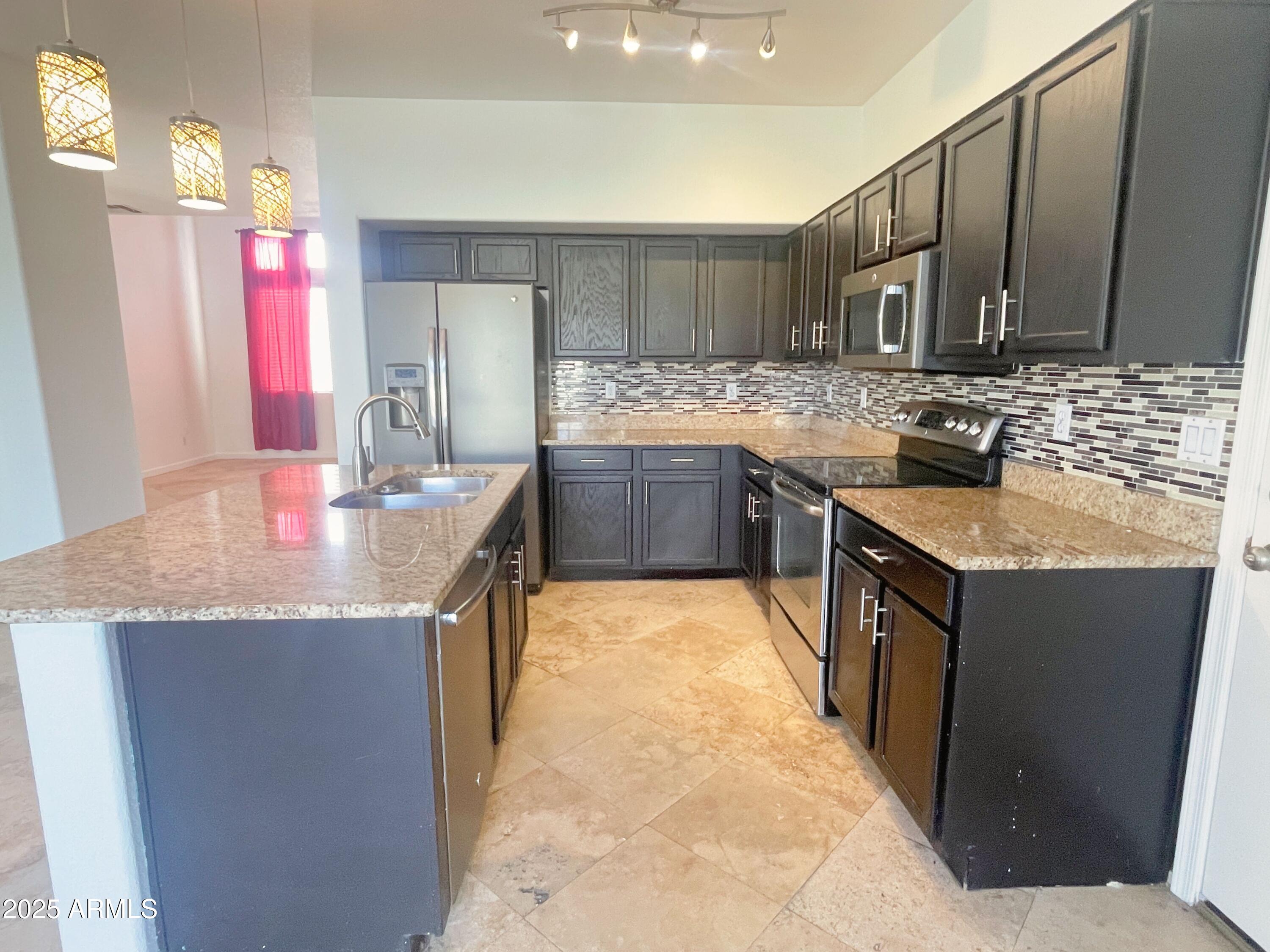 2211 South Harper Mesa, AZ 85209 - Photo 6 of 27 a kitchen with granite countertop a sink stove and cabinets