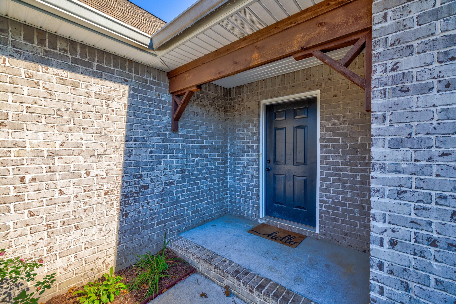1253 Sugar Flat Road Lebanon, TN 37087 - Photo 3 of 32 a brick building with a bench and potted plant