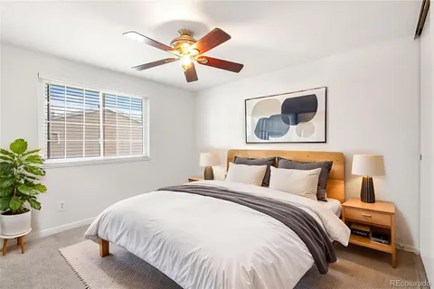 a bedroom with a large bed and a potted plant