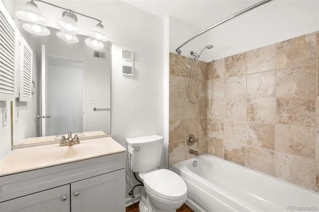 a bathroom with a sink a toilet a mirror a bathtub and shower