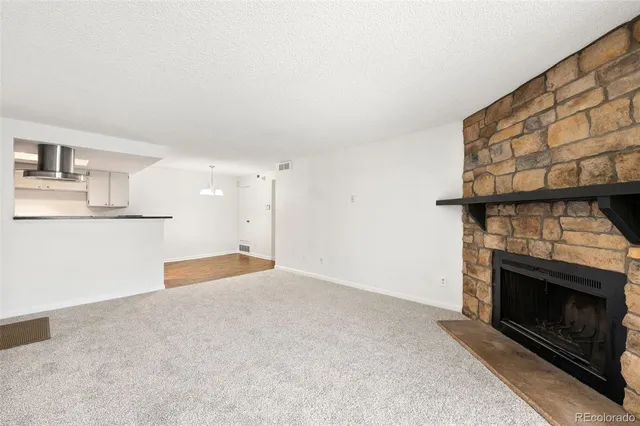 a view of empty room with kitchen