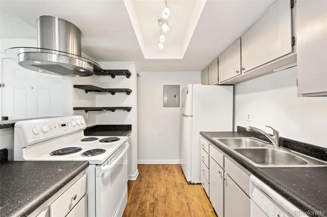 a kitchen that has a sink a stove and a refrigerator