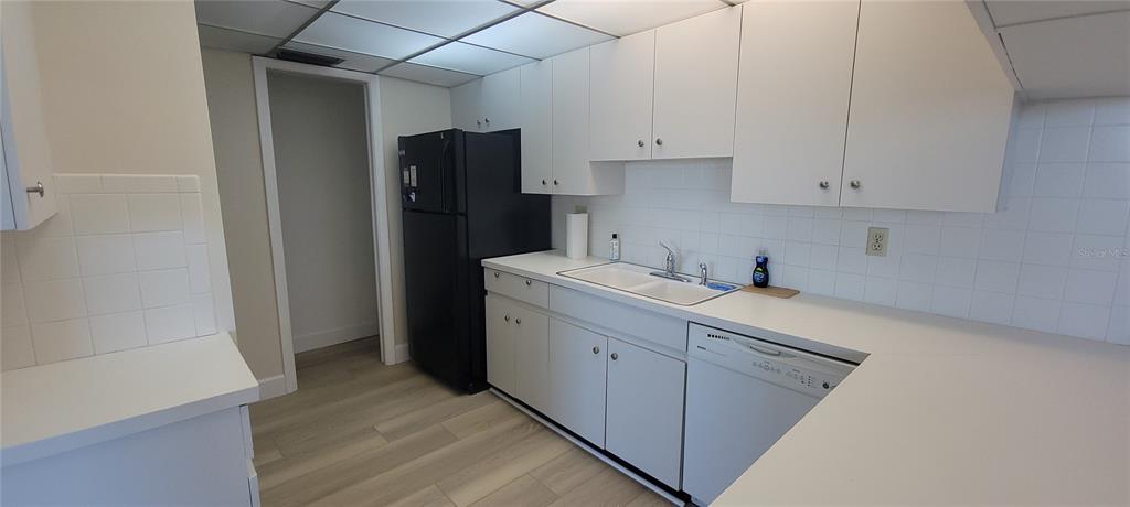 632 Edgewater Drive, Unit 235 Dunedin, FL 34698 - Photo 13 of 37 a kitchen with refrigerator and cabinets
