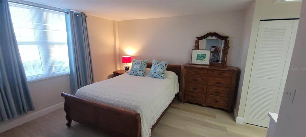 632 Edgewater Drive, Unit 235 Dunedin, FL 34698 - Photo 16 of 37 a bed sitting in a bedroom next to a window