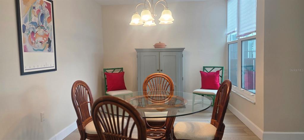 632 Edgewater Drive, Unit 235 Dunedin, FL 34698 - Photo 5 of 37 a view of a dining room with furniture and chandelier
