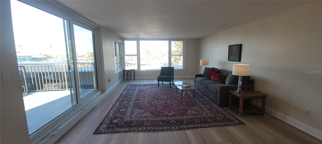 632 Edgewater Drive, Unit 235 Dunedin, FL 34698 - Photo 6 of 37 a living room with a rug couches and a coffee table