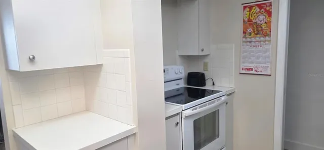 a kitchen with white cabinets and a stove