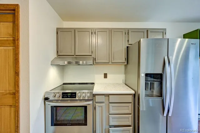 a kitchen with refrigerator a stove and cabinets