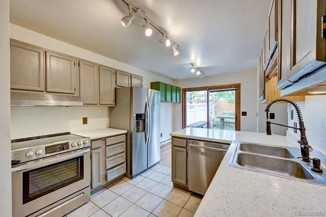 a kitchen with stainless steel appliances granite countertop a stove a sink and a refrigerator