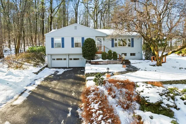 a front view of a house with a yard covered with snow