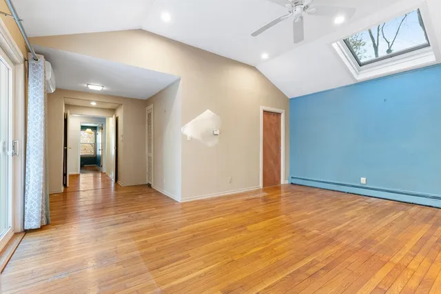 a view of an empty room with wooden floor