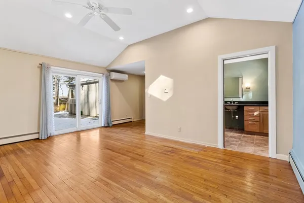 an empty room with wooden floor and mirror