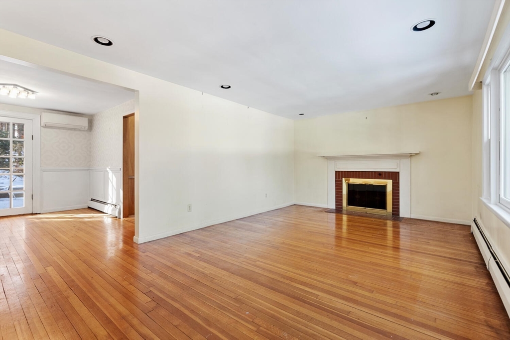 7 Kelley Road Acton, MA 01720 - Photo 5 of 14 an empty room with wooden floor and fireplace
