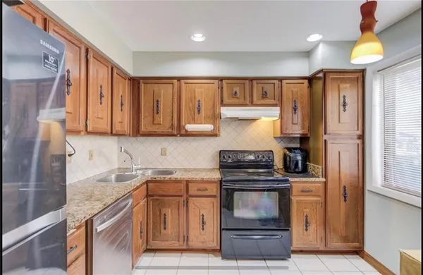 a kitchen with granite countertop a stove and a sink