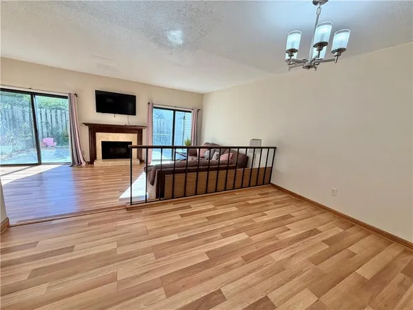 a view of empty room with wooden floor and fireplace