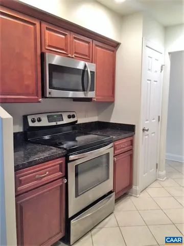 a kitchen with stainless steel appliances granite countertop a stove microwave and sink