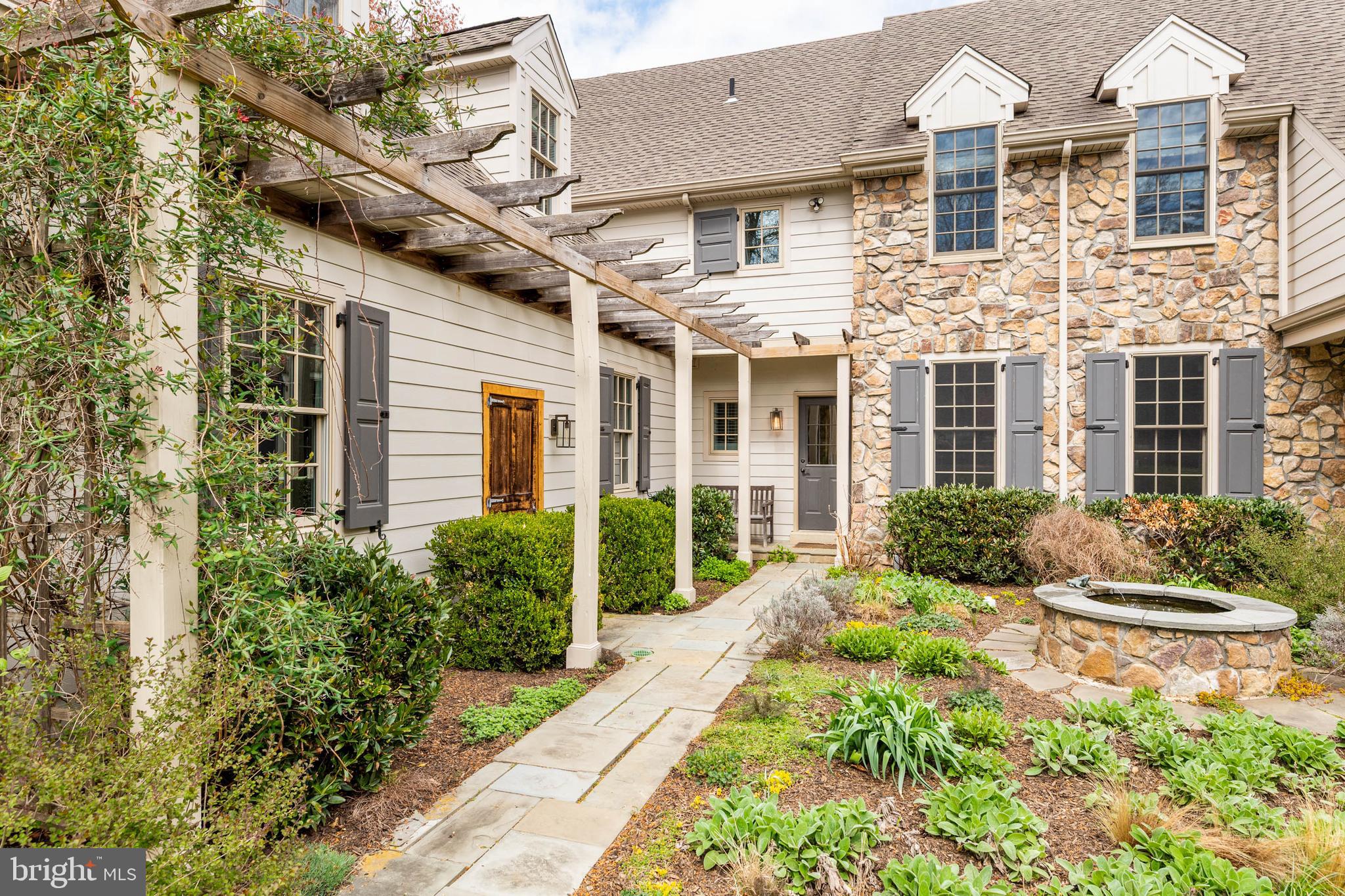 607 Newtown Road Berwyn, PA 19312 - Photo 5 of 83 a view of a brick house with potted plants next to a road