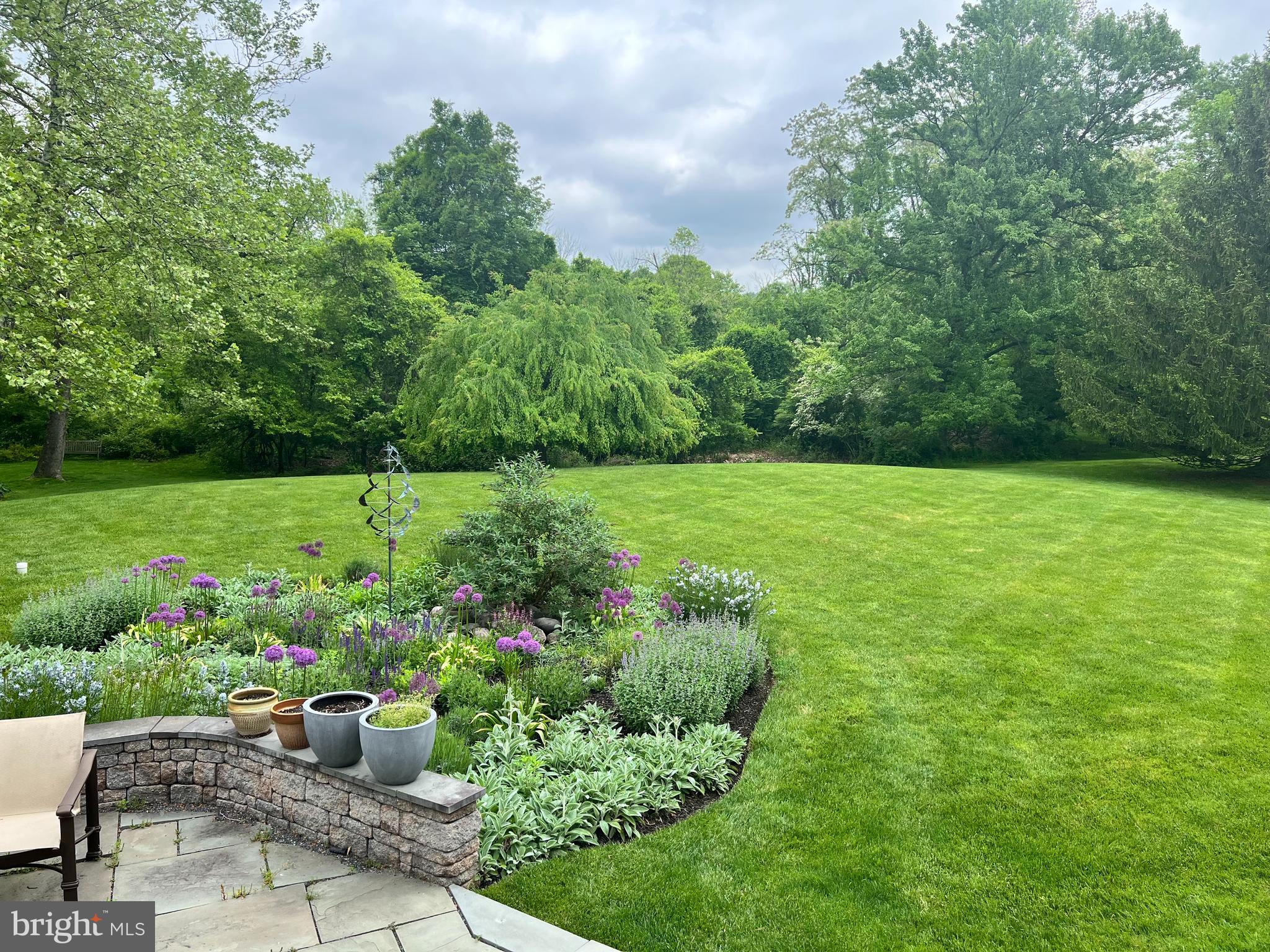 607 Newtown Road Berwyn, PA 19312 - Photo 77 of 83 a view of a garden with a potted plants and large trees