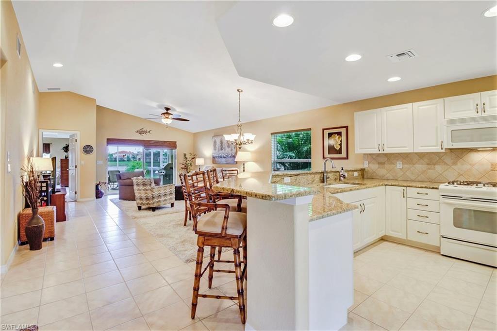 19667 Villa Rosa Loop Estero, FL 33967 - Photo 3 of 19 a kitchen with stainless steel appliances kitchen island granite countertop a refrigerator and cabinets