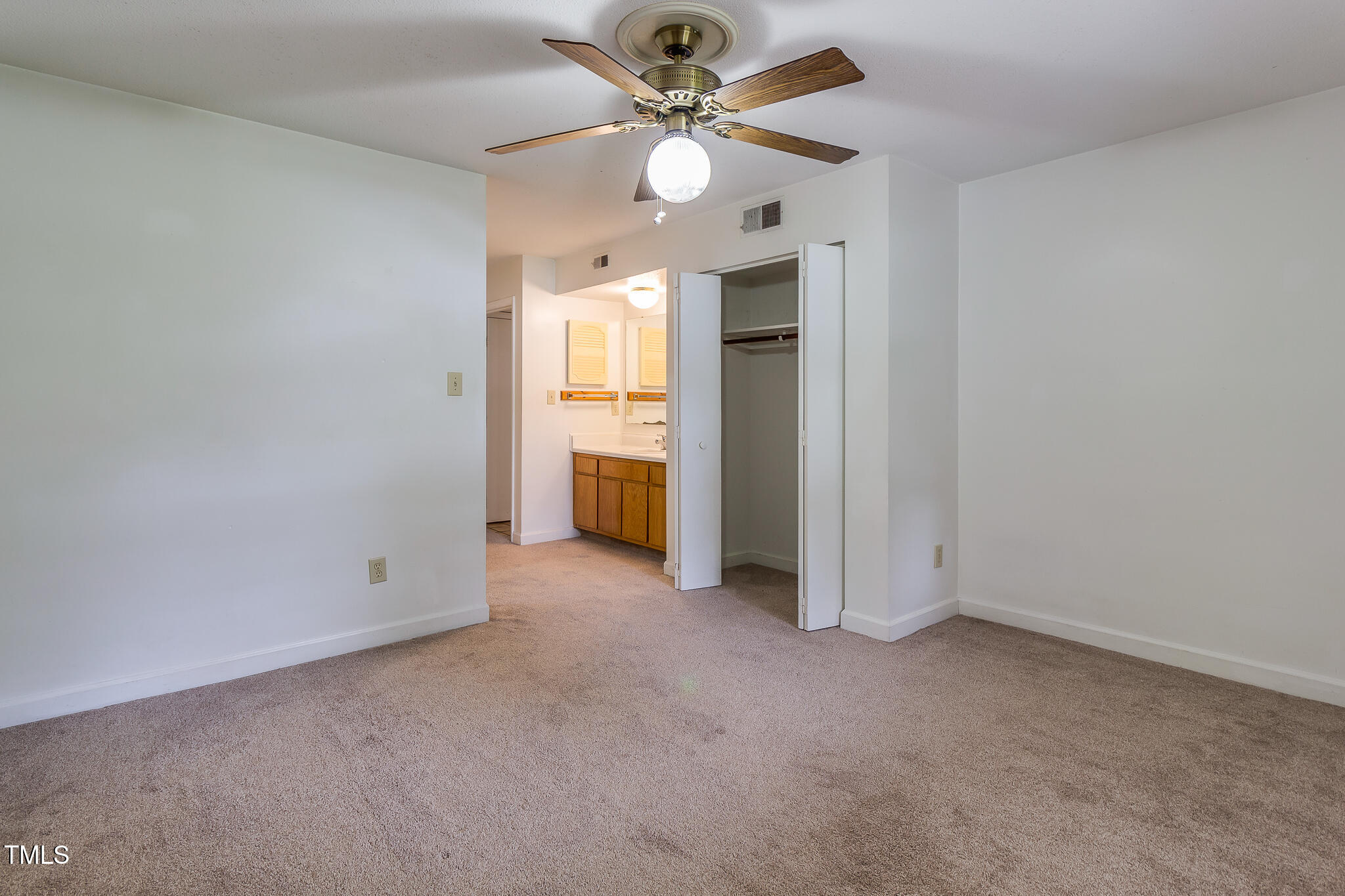 2522 Avent Ferry Road, Unit 103 Raleigh, NC 27606 - Photo 13 of 25 an empty room with chandelier fan and windows