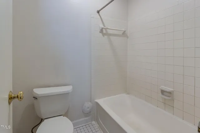 a white toilet sitting next to a bath tub
