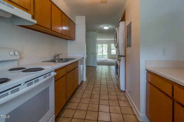 a kitchen with a sink a stove cabinets and a wooden floor