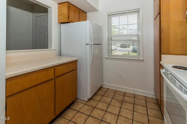 a view of a kitchen with refrigerator and window