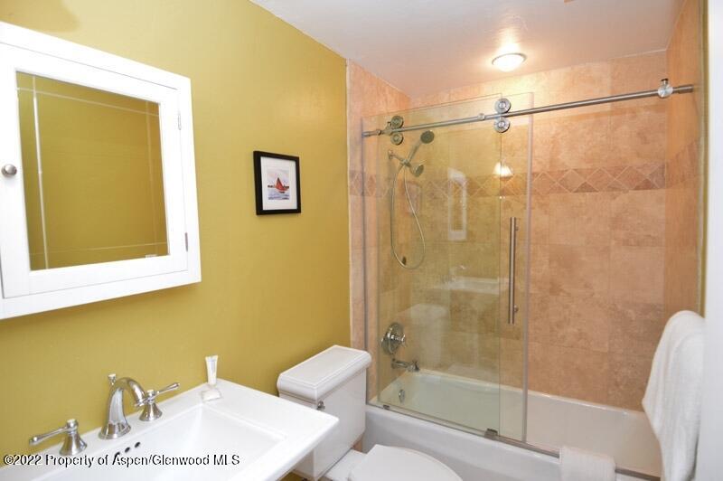 940 Waters Avenue, Unit 307 Aspen, CO 81611 - Photo 11 of 14 a bathroom with a shower a sink and a mirror