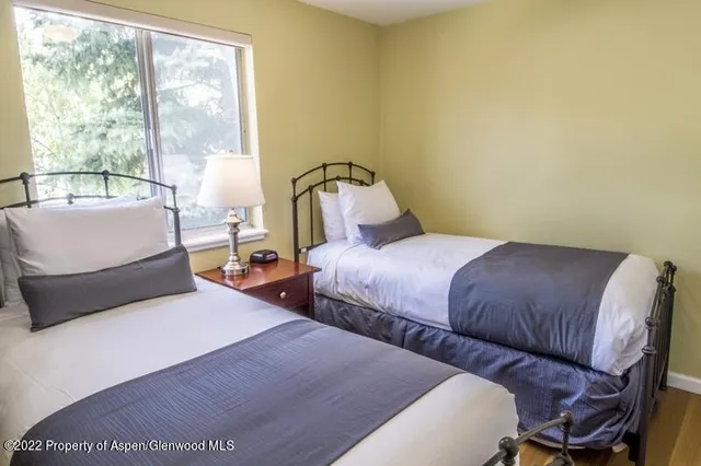 a bedroom with two beds and a large window