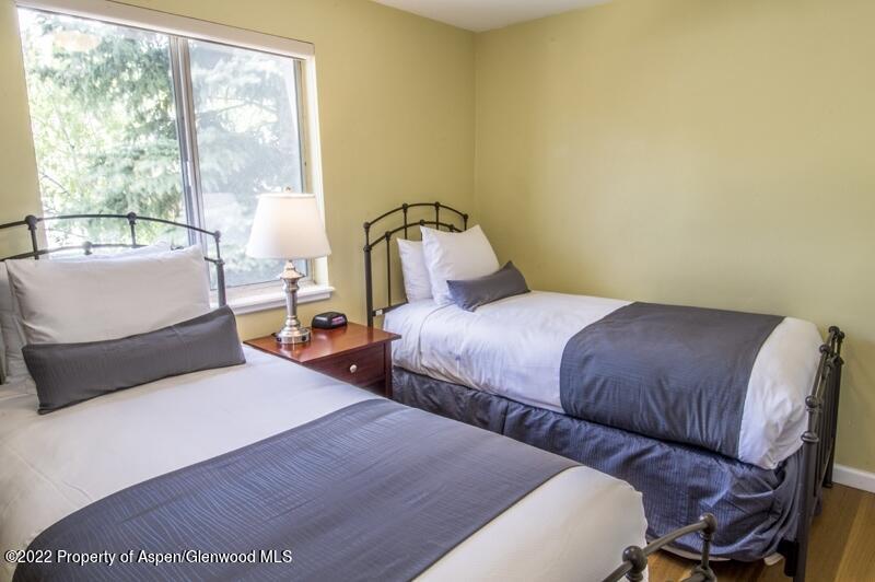 940 Waters Avenue, Unit 307 Aspen, CO 81611 - Photo 9 of 14 a bedroom with two beds and a large window