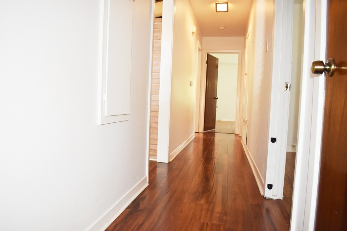 5126 Beechnut Street Houston, TX 77096 - Photo 12 of 20 a view of a hallway with wooden floor