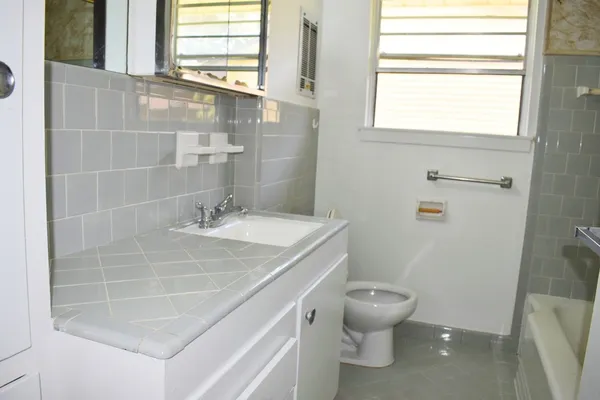 a bathroom with a sink a toilet and a window