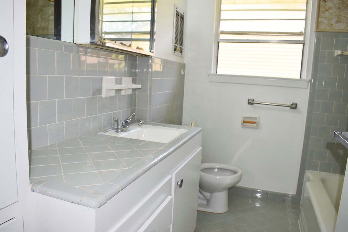 5126 Beechnut Street Houston, TX 77096 - Photo 16 of 20 a bathroom with a sink a toilet and a window