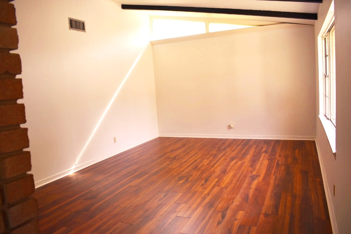 5126 Beechnut Street Houston, TX 77096 - Photo 5 of 20 an empty room with wooden floor and windows