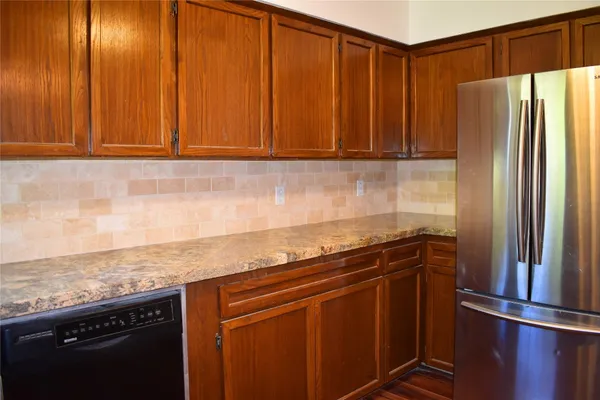 a kitchen with stainless steel appliances granite countertop a refrigerator and a sink