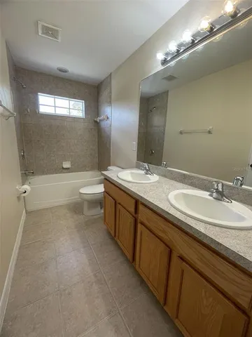 a bathroom with a double vanity sink a toilet and a mirror