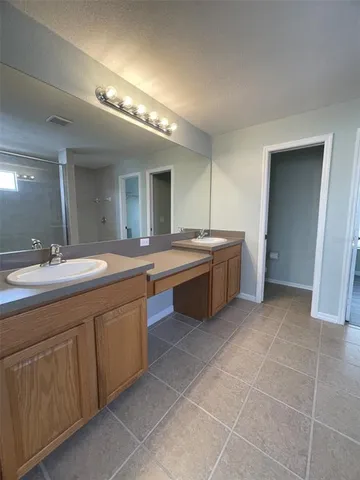 a spacious bathroom with a double vanity sink and a mirror