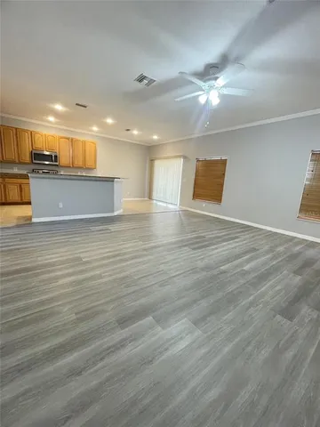 a view of an empty room with wooden floor
