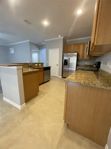 a large kitchen with wooden floors and stainless steel appliances