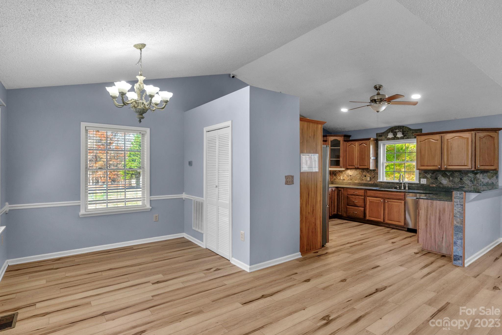 7861 Fisher Road Mount Pleasant, NC 28124 - Photo 11 of 48 a kitchen with stainless steel appliances granite countertop a refrigerator a sink dishwasher a stove and a dining table with wooden floor
