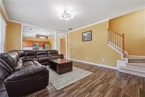 a living room with furniture and a wooden floor