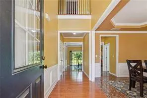 a view of a hallway with wooden floor and staircase