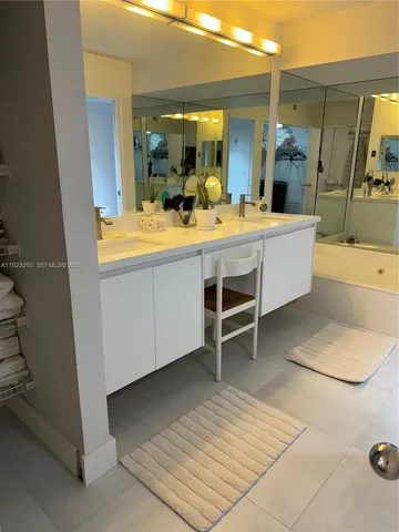 a bathroom with a tub sink and mirror