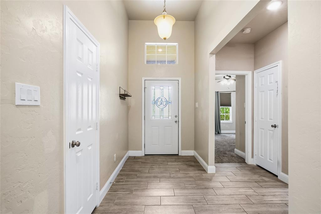 1502 Reed Street Greenville, TX 75401 - Photo 4 of 26 Entryway featuring wood-finish flooring, a decorative glass front door with transom window, and neutral wall tones