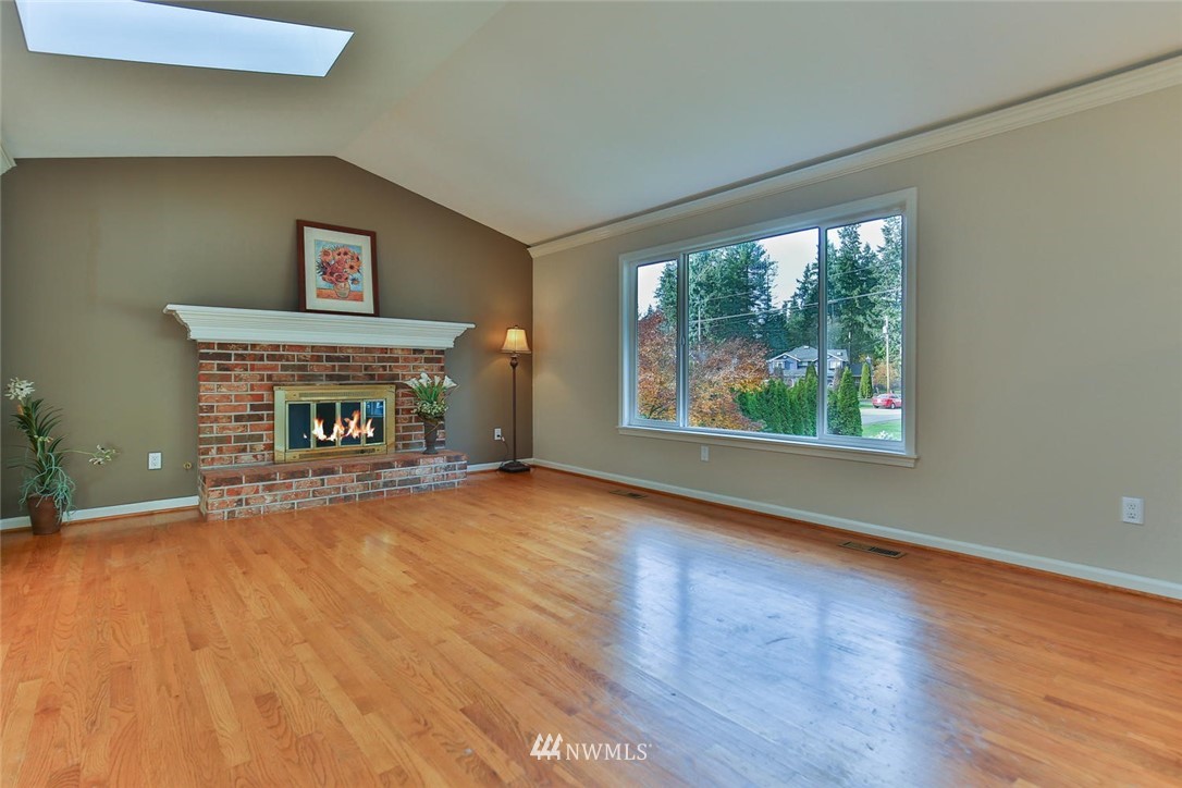 404 170th Place Southwest Bothell, WA 98012 - Photo 4 of 25 a view of an empty room with wooden floor fireplace and a window
