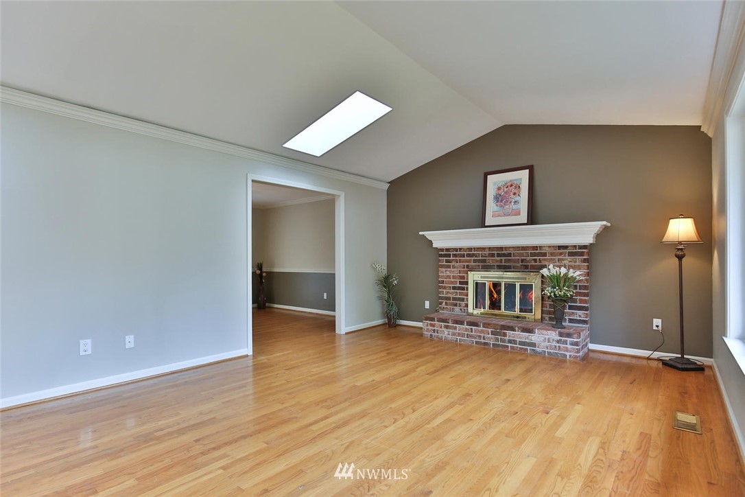 404 170th Place Southwest Bothell, WA 98012 - Photo 5 of 25 an empty room with a fireplace and wooden floor