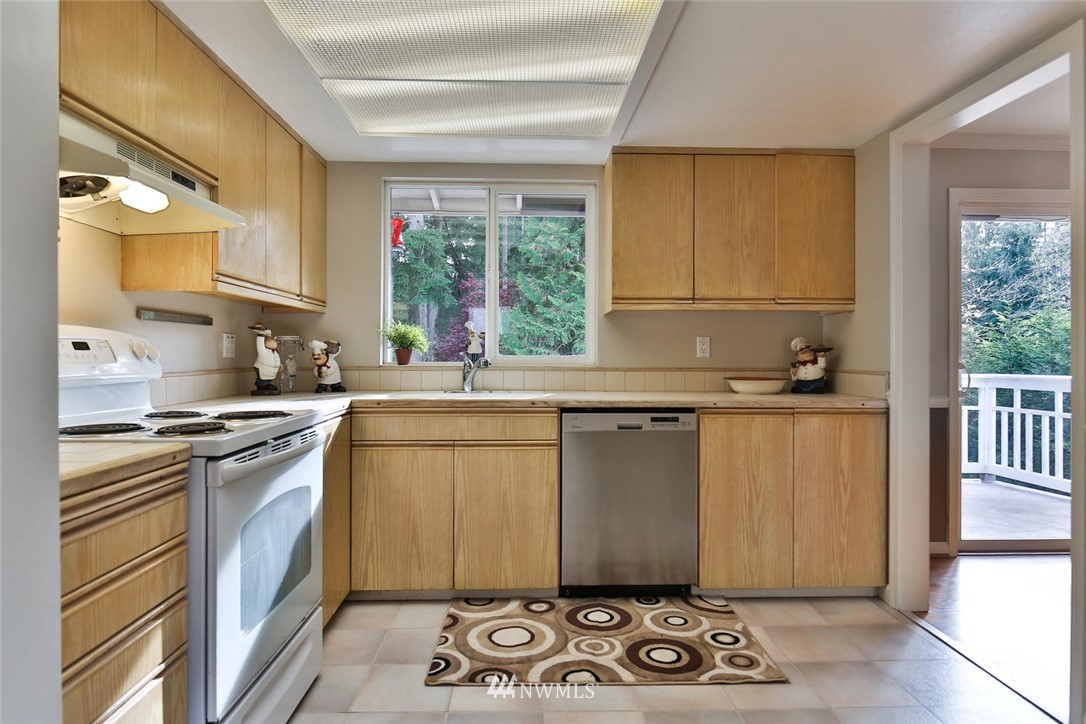 404 170th Place Southwest Bothell, WA 98012 - Photo 8 of 25 a kitchen with granite countertop a sink a stove top oven and cabinetry